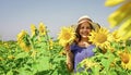 teen girl in sunflower field. concept of summer vacation. rich harvest and agriculture. happy childhood. kid wear straw Royalty Free Stock Photo