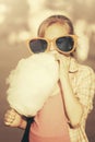 Teen girl in sunglasses eating cotton candy on city street Royalty Free Stock Photo