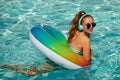 Teen girl in swimming pool playing in water. Vacation and traveling. Young woman with floating ring in swimming pool