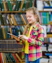 Teen girl with tablet computer in a library Royalty Free Stock Photo