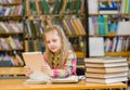 Teen girl with tablet computer working in library Royalty Free Stock Photo