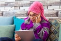 Teen girl talking on a cell phone. He is holding a tablet in his hand and looking at it with surprise Royalty Free Stock Photo