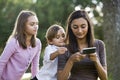 Teen girl texting, younger siblings watch