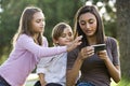 Teen girl texting, younger siblings watch