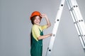 teen girl in uniform and helmet with ladder. female builder in hard hat.
