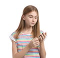 Teen girl using glucometer on white background.