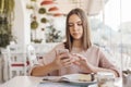Teen girl using smart phone in cafe Royalty Free Stock Photo