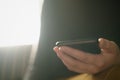 Teen girl using smartphone backlit by window light