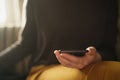 Teen girl using smartphone backlit by window light