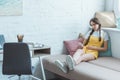 teen girl using smartphone and sitting on sofa