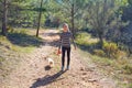 Teen girl walking with a white dog in forest Royalty Free Stock Photo