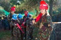 Teen girl wearing uniform and holding gun ready for playing with friends on paintball outdoor
