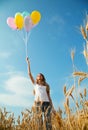 Teen girl at a wheat field with balloons Royalty Free Stock Photo
