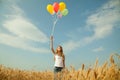 Teen girl at a wheat field with balloons Royalty Free Stock Photo