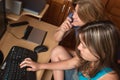 Teen girl working on a computer with her mother Royalty Free Stock Photo