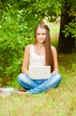 Teen girl works with the laptop on the grass Royalty Free Stock Photo