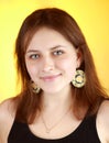 Vertical portrait of a girl 17 years of age on a yellow background, gray-eyed, smiling. Royalty Free Stock Photo