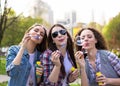 Teen girls blowing soap bubbles. Young happy teenagers having fun in summer park. Royalty Free Stock Photo