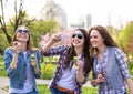 Teen girls blowing soap bubbles. Young happy teenagers having fun in summer park. Royalty Free Stock Photo