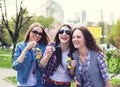 Teen girls blowing soap bubbles. Young happy teenagers having fun in summer park. Royalty Free Stock Photo