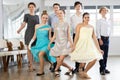 Teen girls curtsy and pose with ballroom dancing boys partners for reporting shot