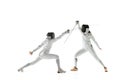 Teen girls in fencing costumes with swords in hands isolated on white background