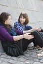 Teen girls sitting on pavement