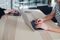 Teen girls studying at desk and doing homeworks, both are using laptops, education concept, unrecognizable people. Royalty Free Stock Photo