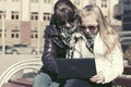Teen girls using laptop on the bench Royalty Free Stock Photo