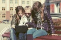 Teen girls using laptop on the bench in city street Royalty Free Stock Photo