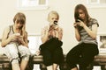 Teen girls using smart phones against a school building Royalty Free Stock Photo