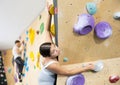 Teen guy practicing rock climbing on climbing wall Royalty Free Stock Photo