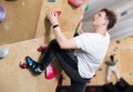 Teen guy practicing rock climbing on climbing wall Royalty Free Stock Photo