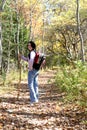 Teen with hiking stick pauses on the trail