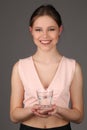 Teen holding glass in her hands. Close up. Gray background Royalty Free Stock Photo