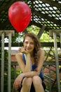 Teen holding a red balloon