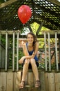 Teen holding a red balloon