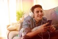 Teen listening music with headphones lying face down multicolored lights