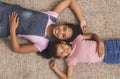 Teen and little african american girls lying together on floor