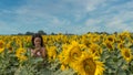 Teen looking at mobile phone while standing in a field surrounded by sunflowers Royalty Free Stock Photo