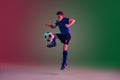 Teen male football or soccer player, boy on gradient background in neon light - motion, action, activity concept Royalty Free Stock Photo