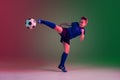 Teen male football or soccer player, boy on gradient background in neon light - motion, action, activity concept Royalty Free Stock Photo