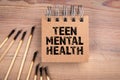 Teen Mental Health. Burnt matches and notepad on a wooden background