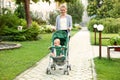 Teen nanny with cute baby in stroller walking