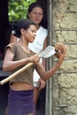 Teen open a coconut for her simple childhood home