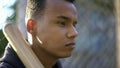 Teen player holding baseball bat, waiting for game, street sport, mental warm-up