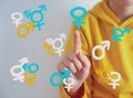 Teen problem Family issues Gender confusion in teenager.  A teen boy pointing at gender symbols of male bigender and transgender. Royalty Free Stock Photo