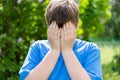 Teen problems - boy covered his face with his hands outside Royalty Free Stock Photo