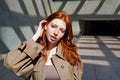 Teen redhead girl looking at camera standing among urban walls. Royalty Free Stock Photo