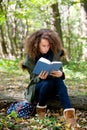 Teen schoolgirl reading book in the autumn park Royalty Free Stock Photo